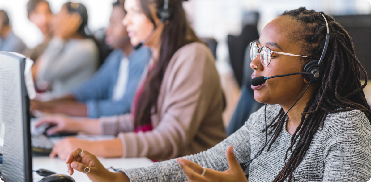 Focused woman with headset engaged in conversation at a call center, symbolizing skilled customer acquisition in action