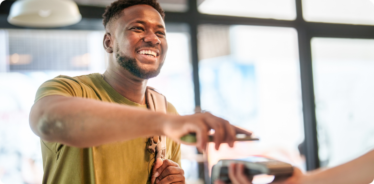 Smiling customer making a mobile payment, representing credit card customer satisfaction driven by smooth and human-centered service.