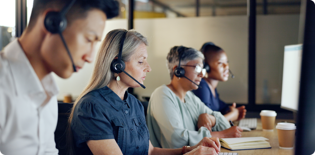 Contact center team on headsets handling complex cases, illustrating AI call deflection effects on workload and focus.
