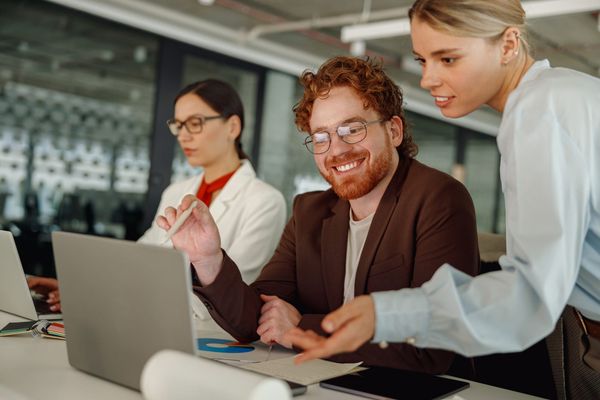 Engaged team collaborating at laptop, representing proactive strategies for building a resilient frontline team