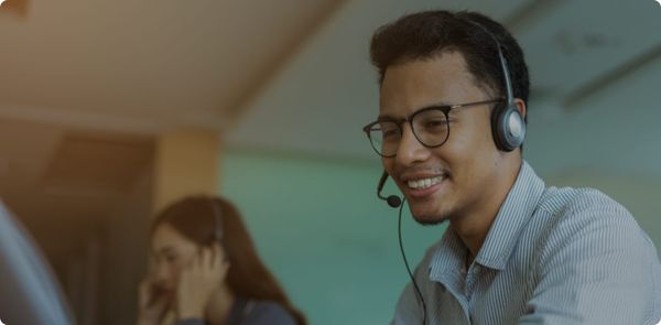 Smiling contact center agent with headset, reflecting positive leadership and coaching culture in modern contact centers