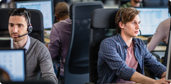 Focused frontline agents using headsets and computers, highlighting the rising impact of AI in the frontline