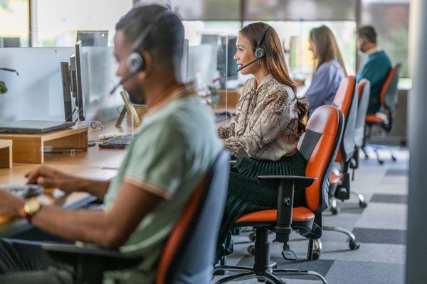 Row of call center agents at workstations, emphasizing the need for a call center early retention strategy