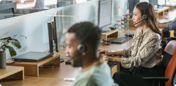 Contact center agents wearing headsets at their desks, reflecting the impact of the Keep Call Centers in America Act on daily operations.