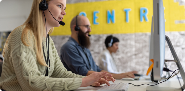 Contact center agents working at computers, illustrating how frontline enablement drives stronger CX results and ROI.