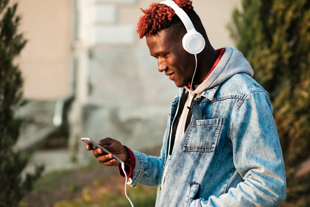 man using headphones connected to a phone - How to Remove Music from TikTok Video