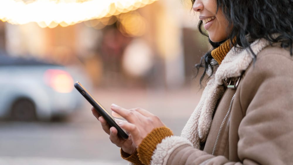 woman in a street using a phone - How to Download YouTube Videos on Android