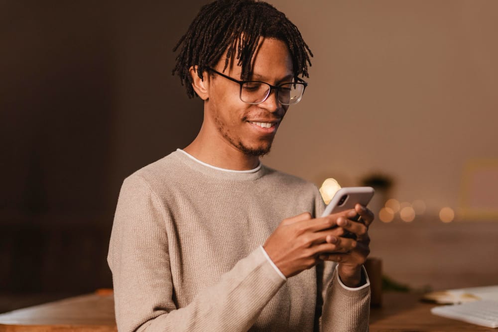 man smiling and using a phone - How to Download YouTube Videos in Mobile Gallery
