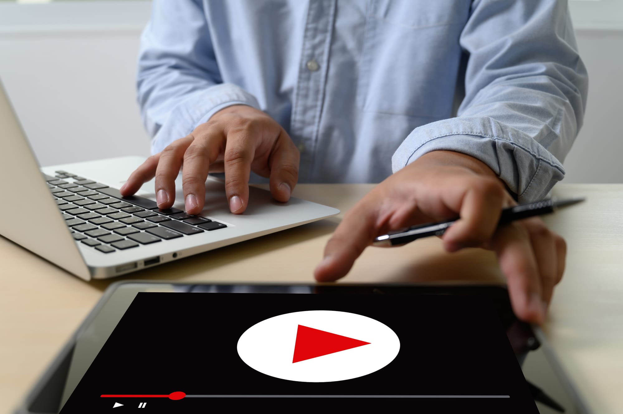 man using a laptop and a tablet - Can You Download YouTube Videos
