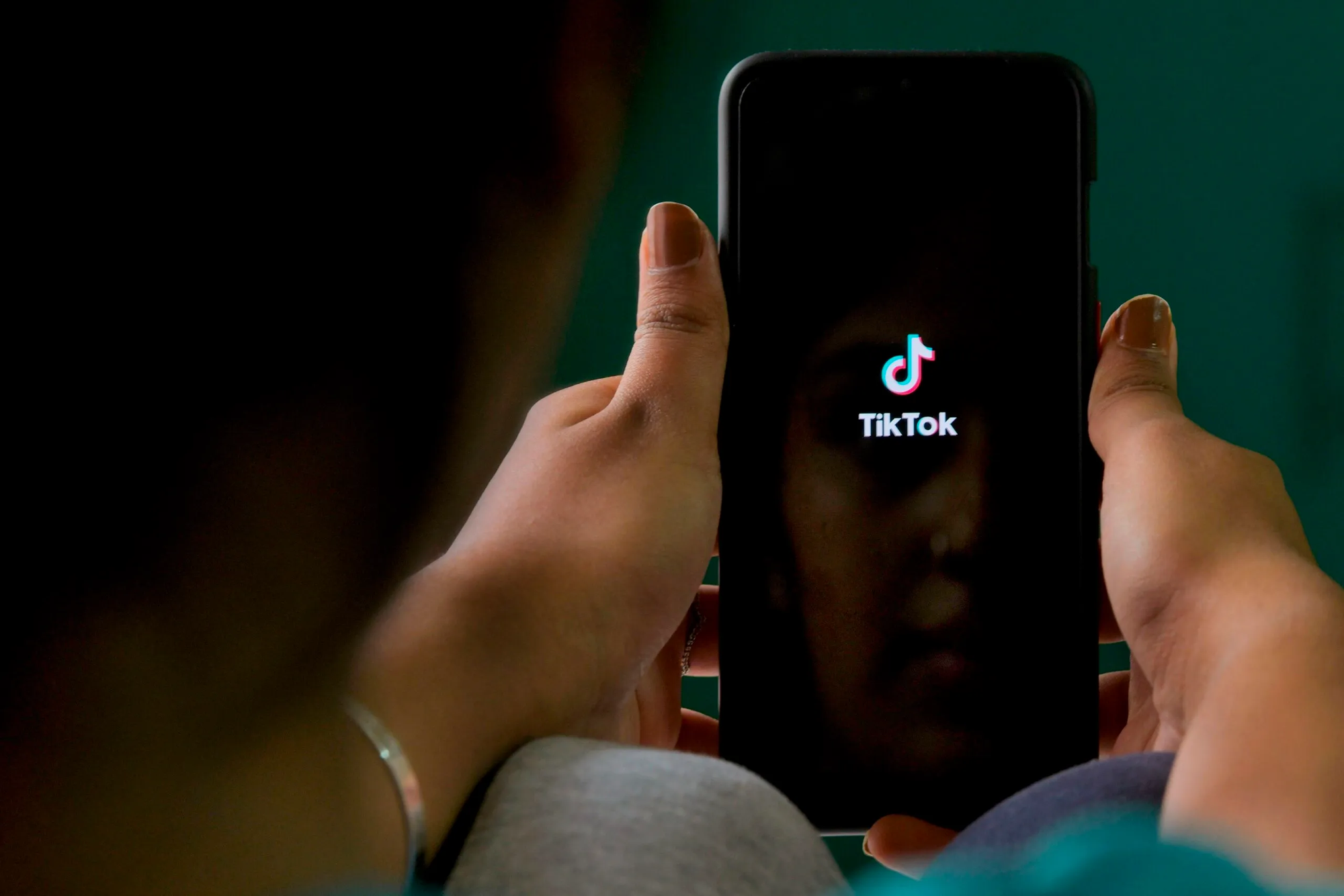woman using tiktok on her phone - How to Download Private TikTok Videos