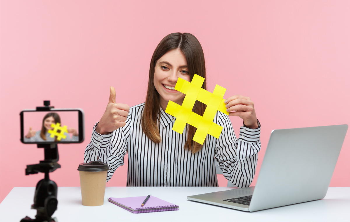 woman holding a hashtag logo - How Much To Charge For Social Media Content Creation