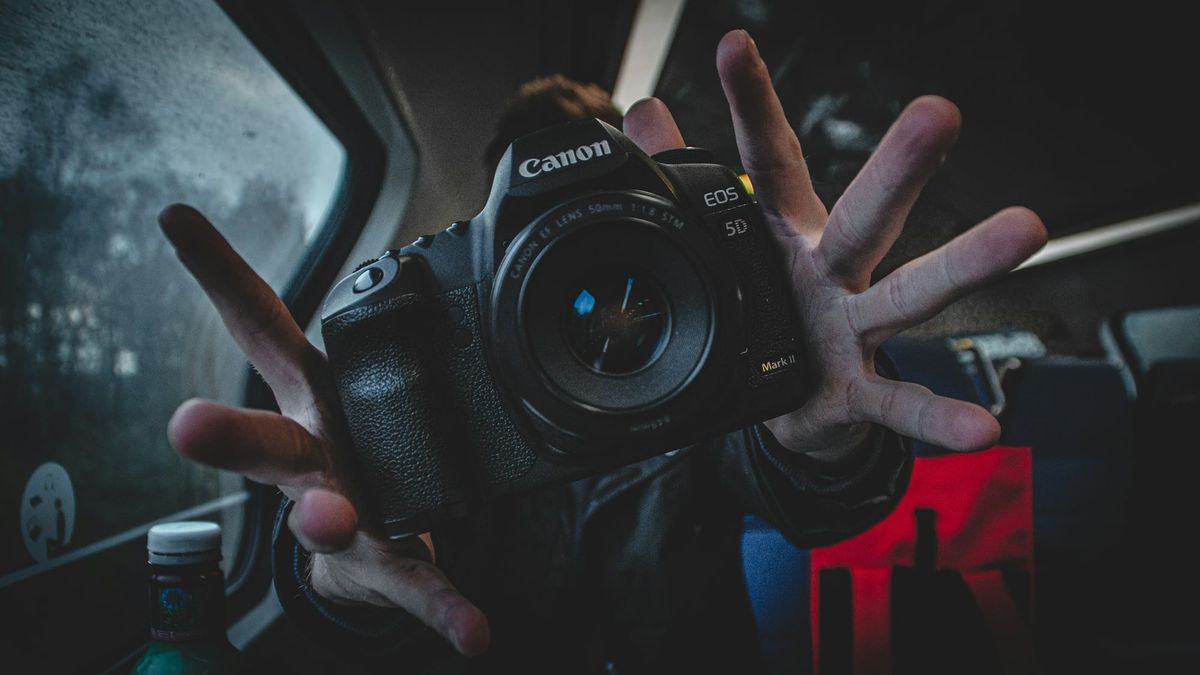 man holding a camera - Can You Repost a Reel on Instagram