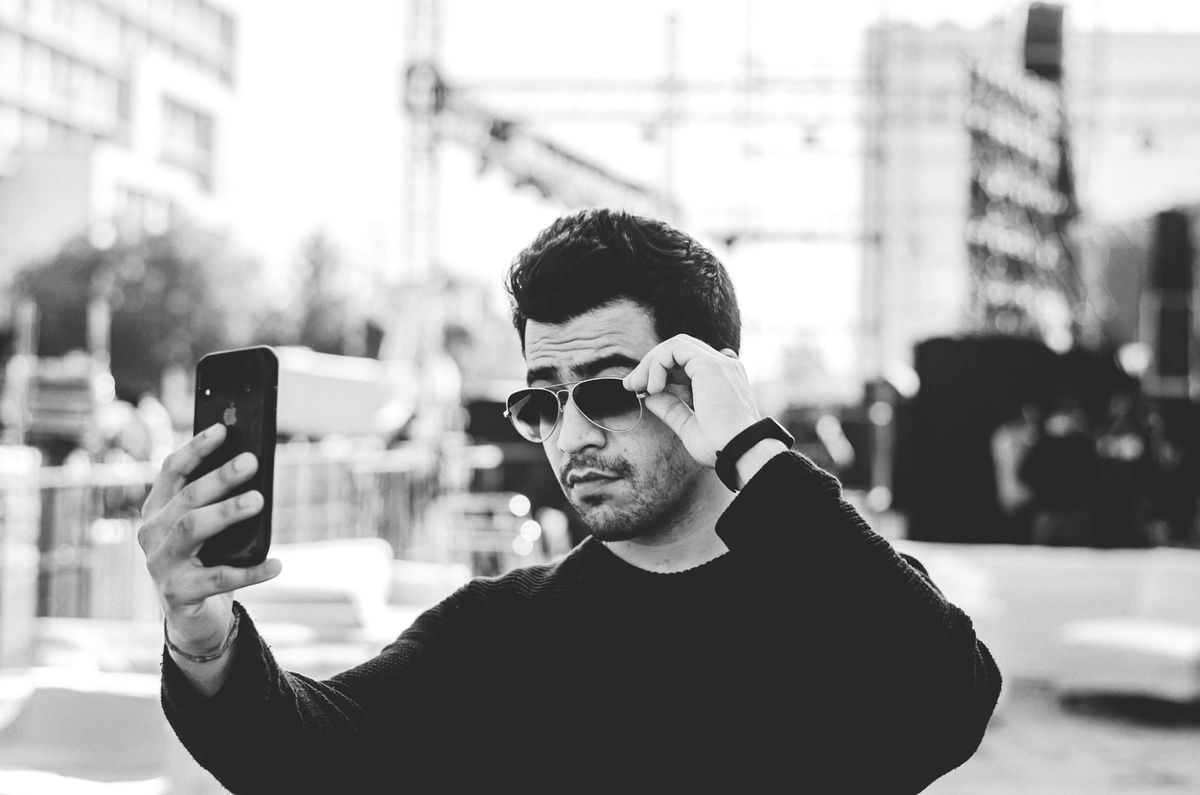 man using his phone - Reel Dimensions Instagram