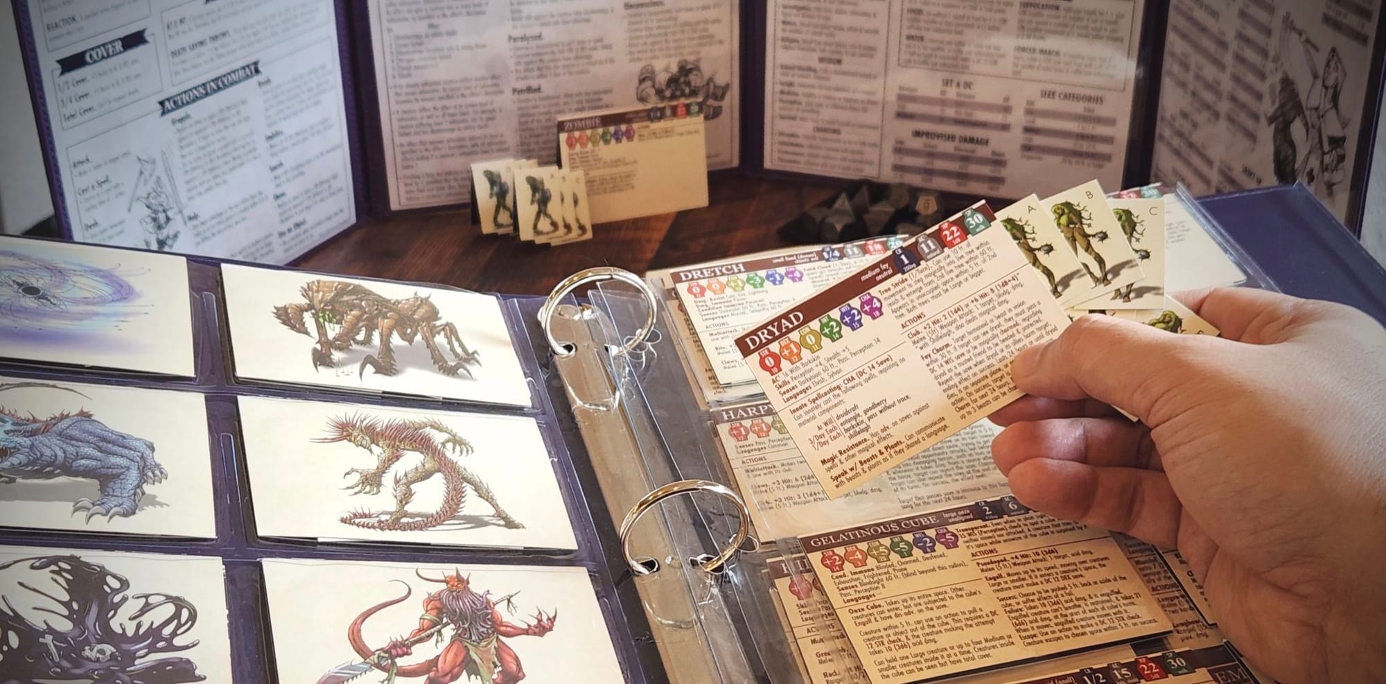 A photograph of a Dungeon Master choosing a paper mini creature to deploy from their Tome.