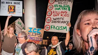 protesters hold signs opposing ice raids