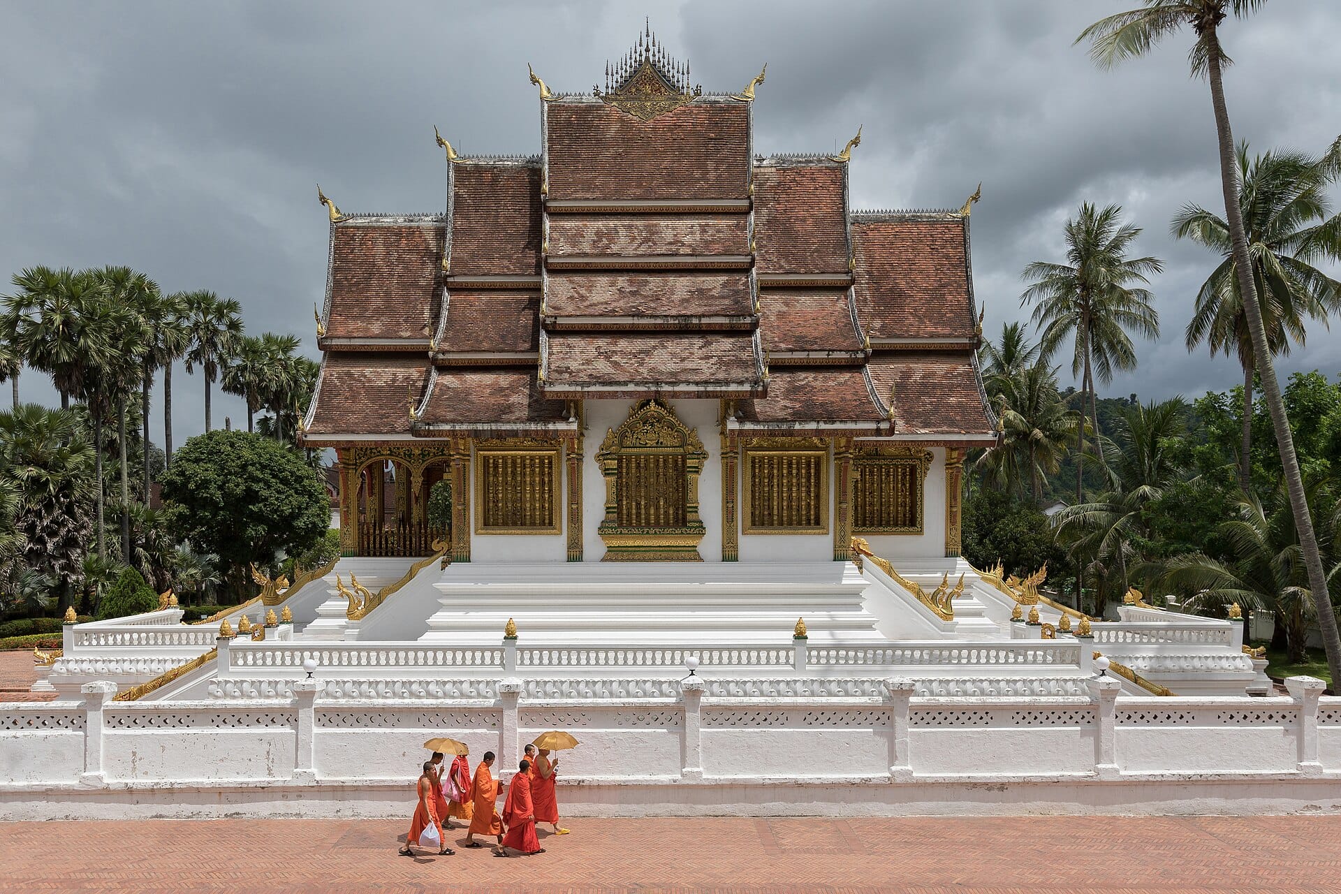 Monks walking in front of the Haw Pha Bang temple at the Royal Palace, Luang Prabang