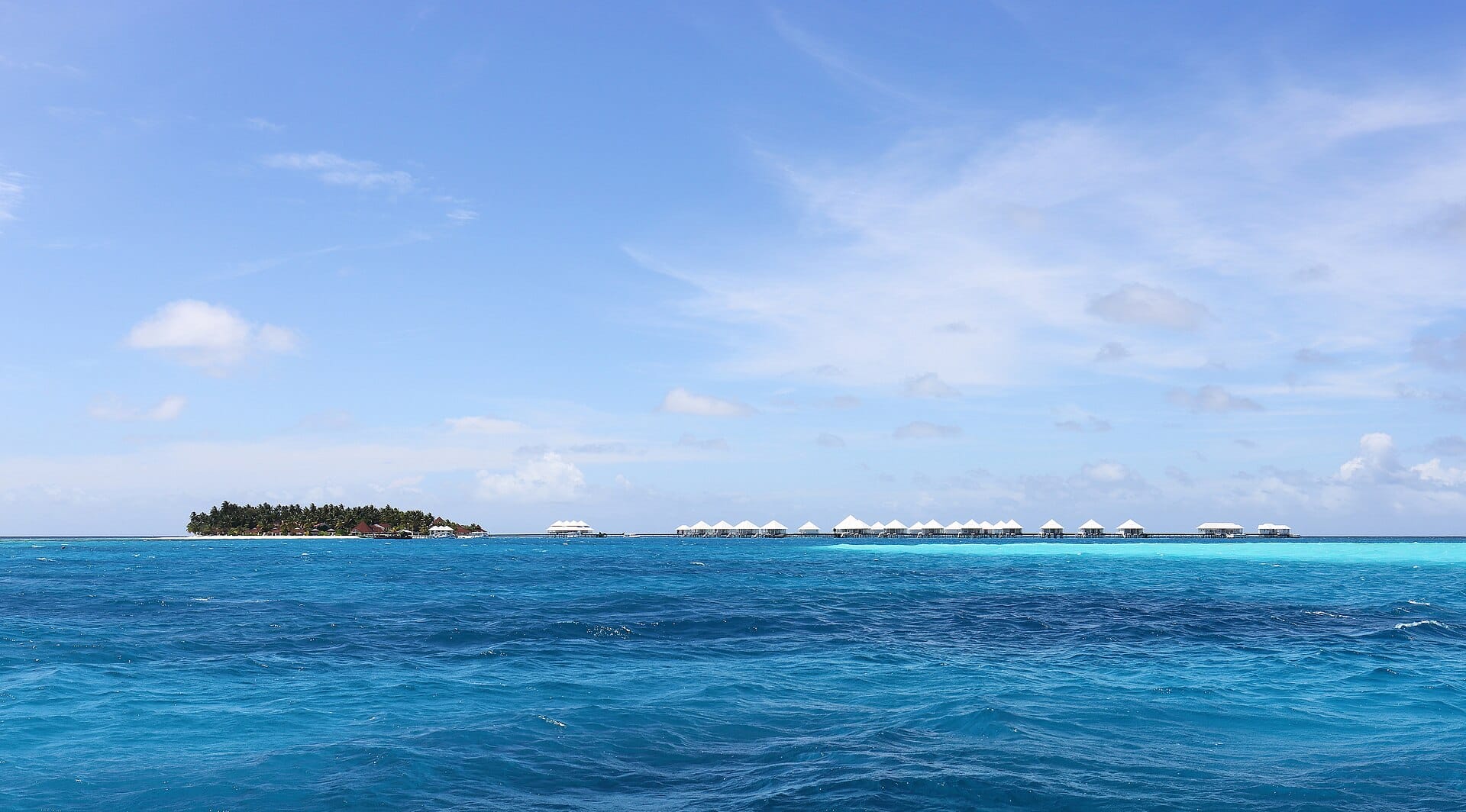 Overwater villas on stilts above a turquoise Maldives lagoon
