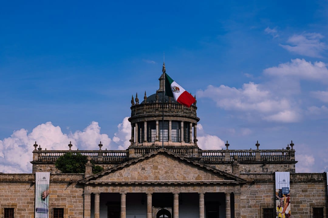 The neoclassical facade of the Hospicio Cabañas in Guadalajara with a Mexican flag