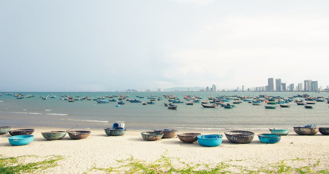 Round basket boats on the shore at My Khe Beach with the city skyline behind