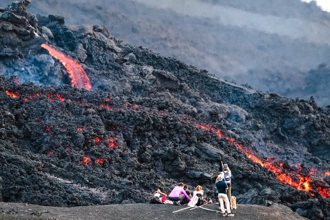 Hikers on the black lava fields of Pacaya volcano