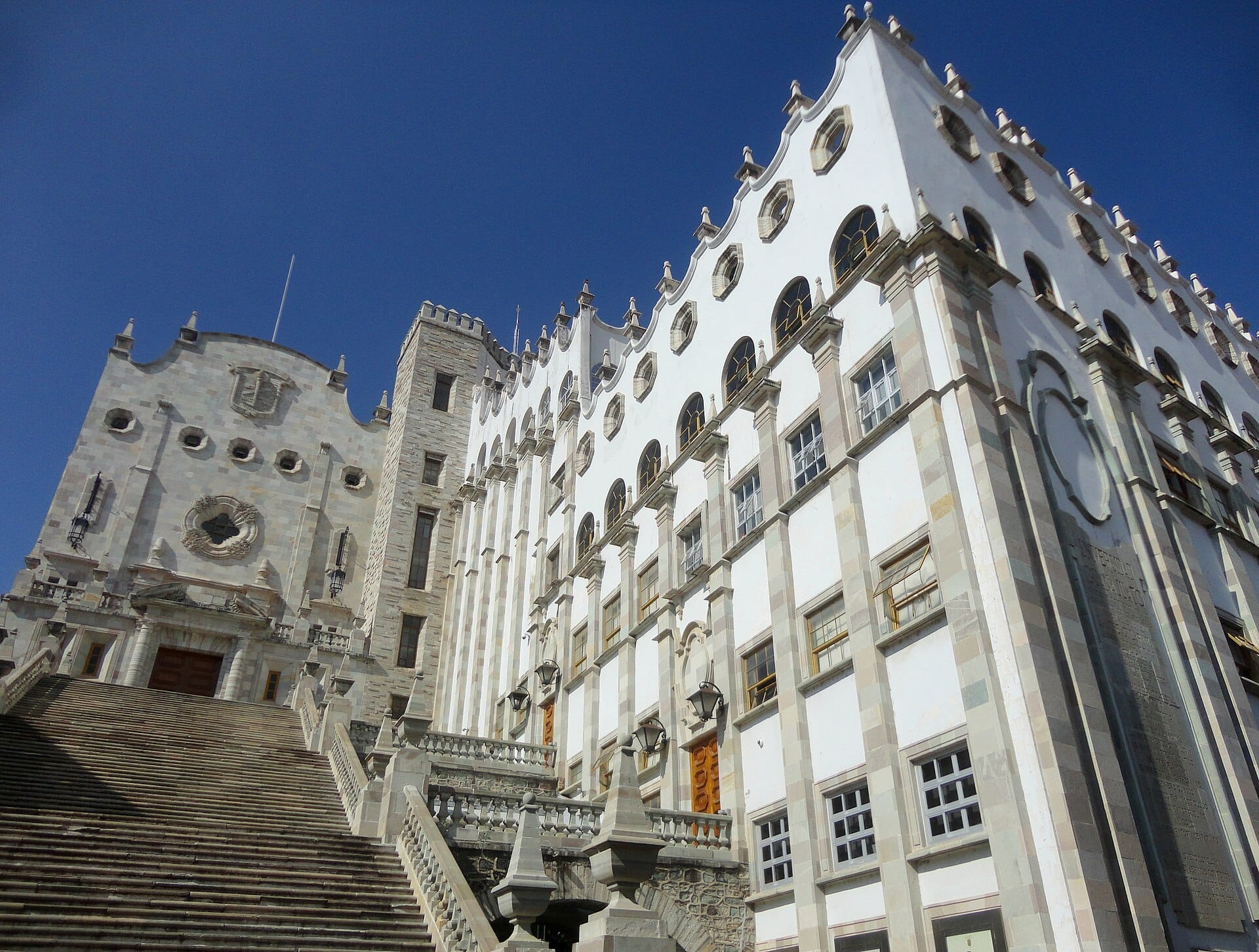 The white central building and grand staircase of the Universidad de Guanajuato