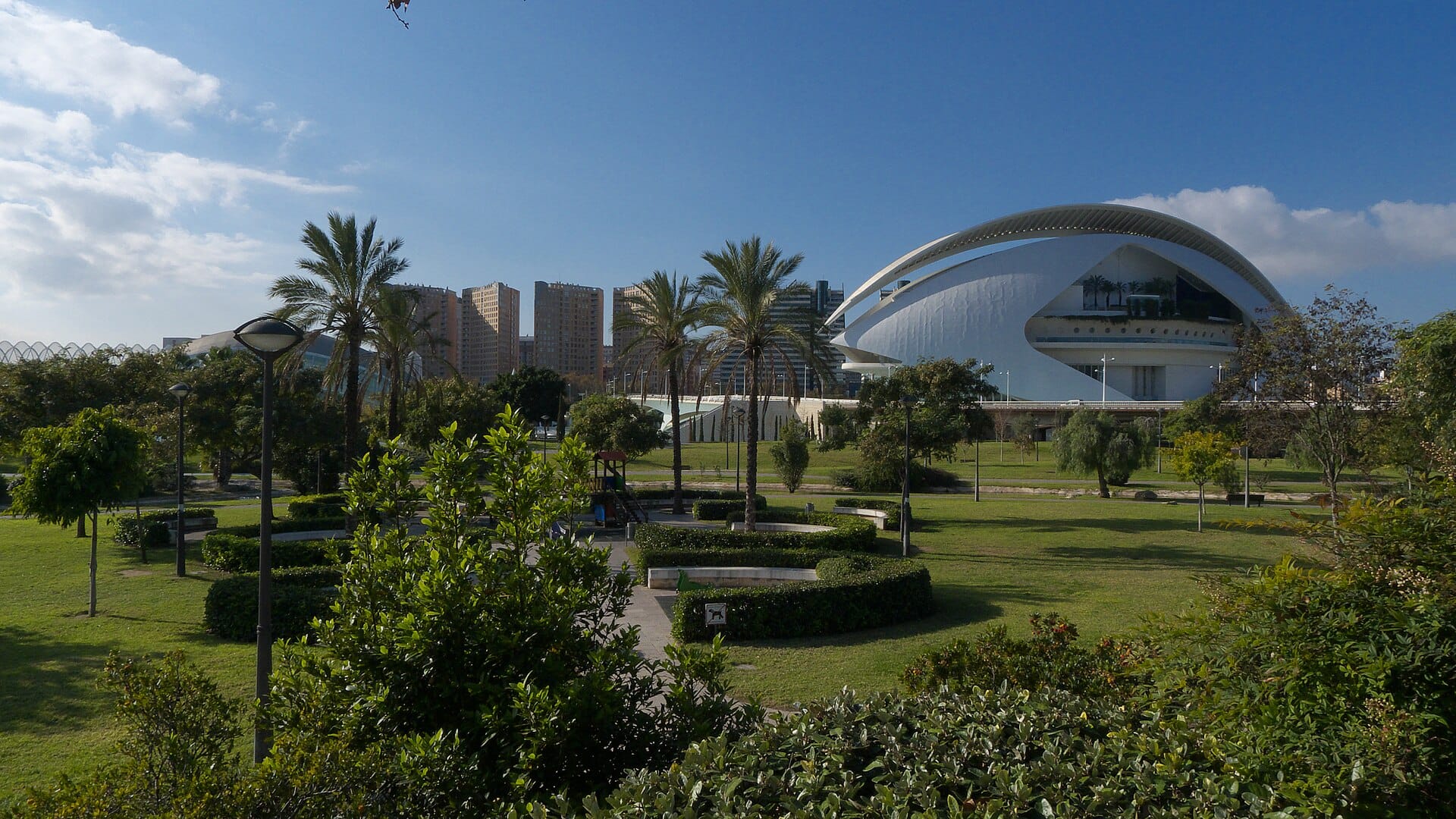 Green lawns, trees and old stone bridges along the Turia Gardens riverbed park