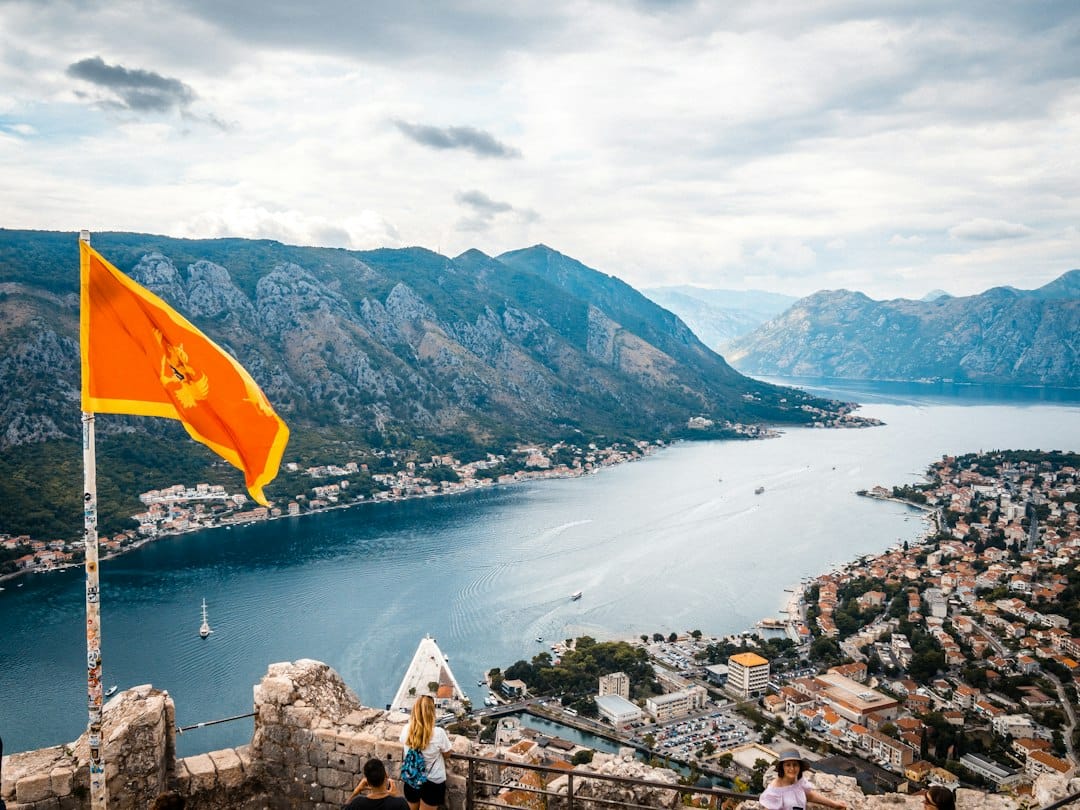 Montenegrin flag flying from the San Giovanni fortress walls above the Bay of Kotor