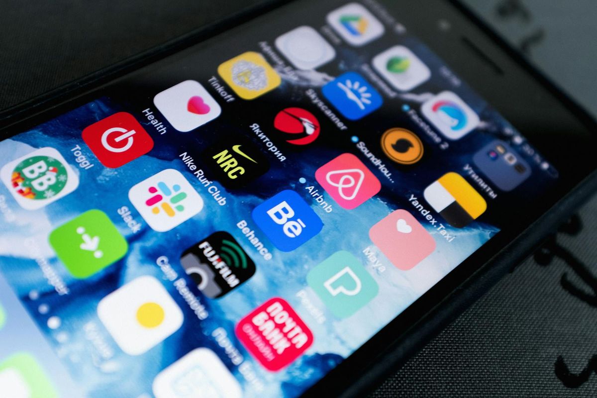 A phone showing a grid of mobile app icons, illustrating the essential apps for a Dubai newcomer
