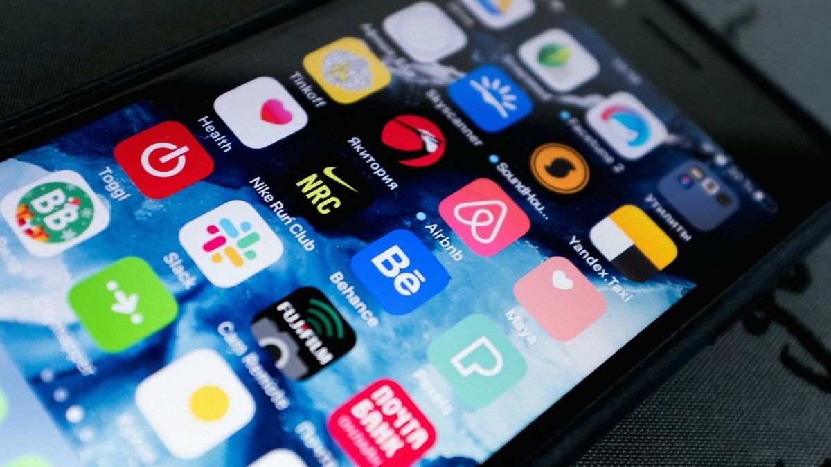 A phone showing a grid of mobile app icons, illustrating the essential apps for a Dubai newcomer