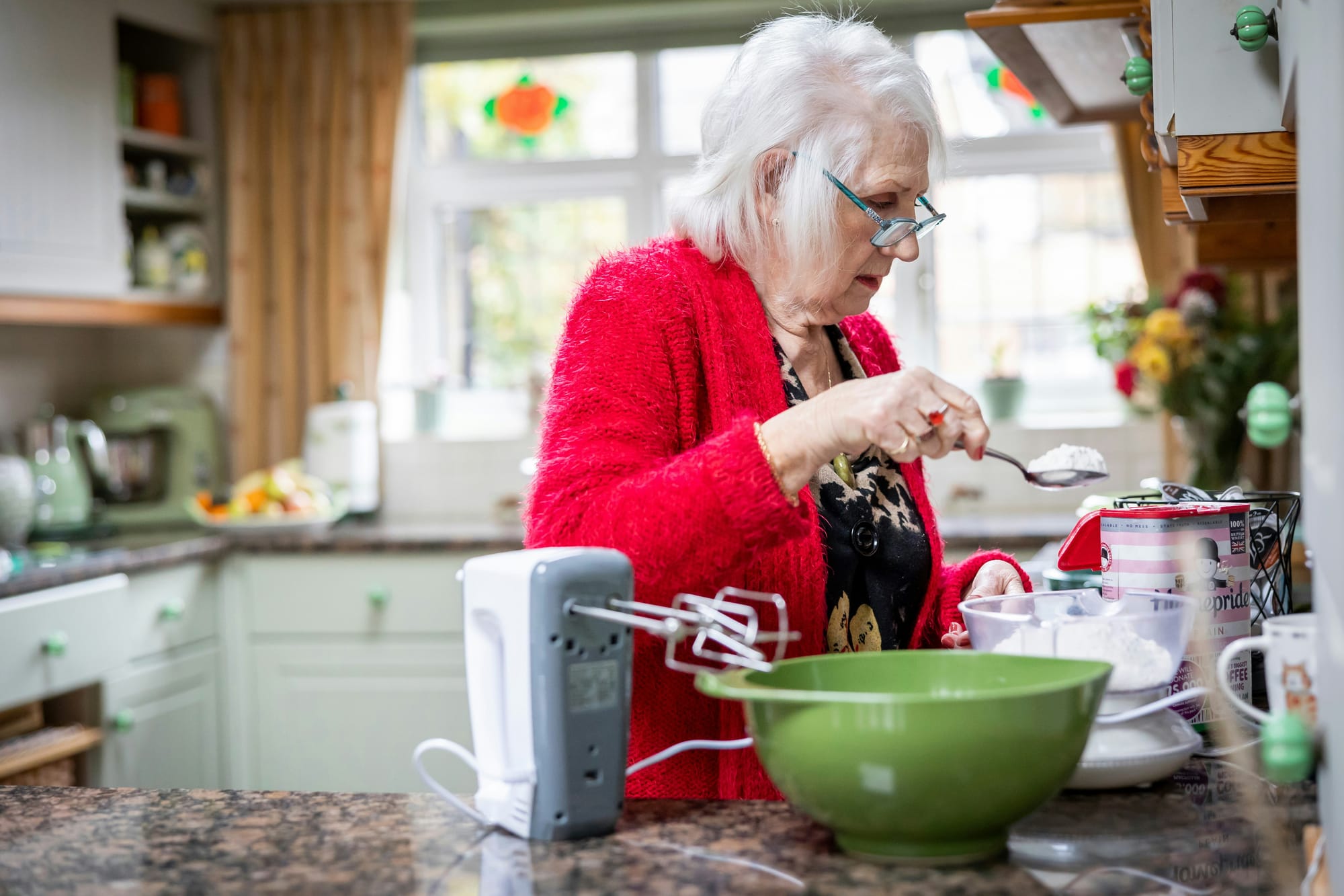 An older woman baking in a bright kitchen