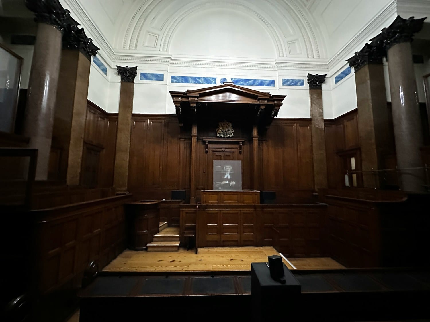The empty wooden interior of a courtroom.