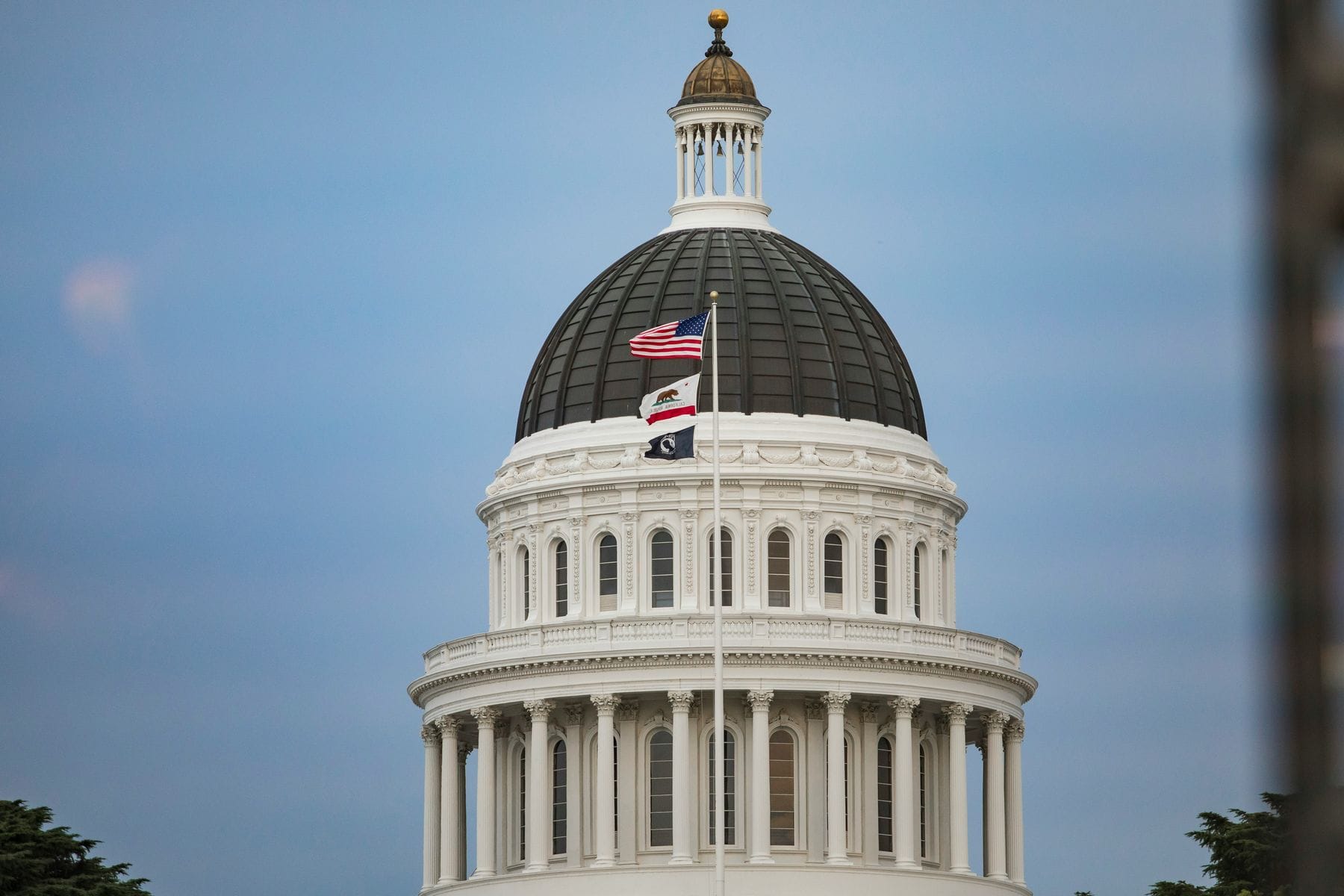 The dome of the California State Capitol with the United States and California flags flying