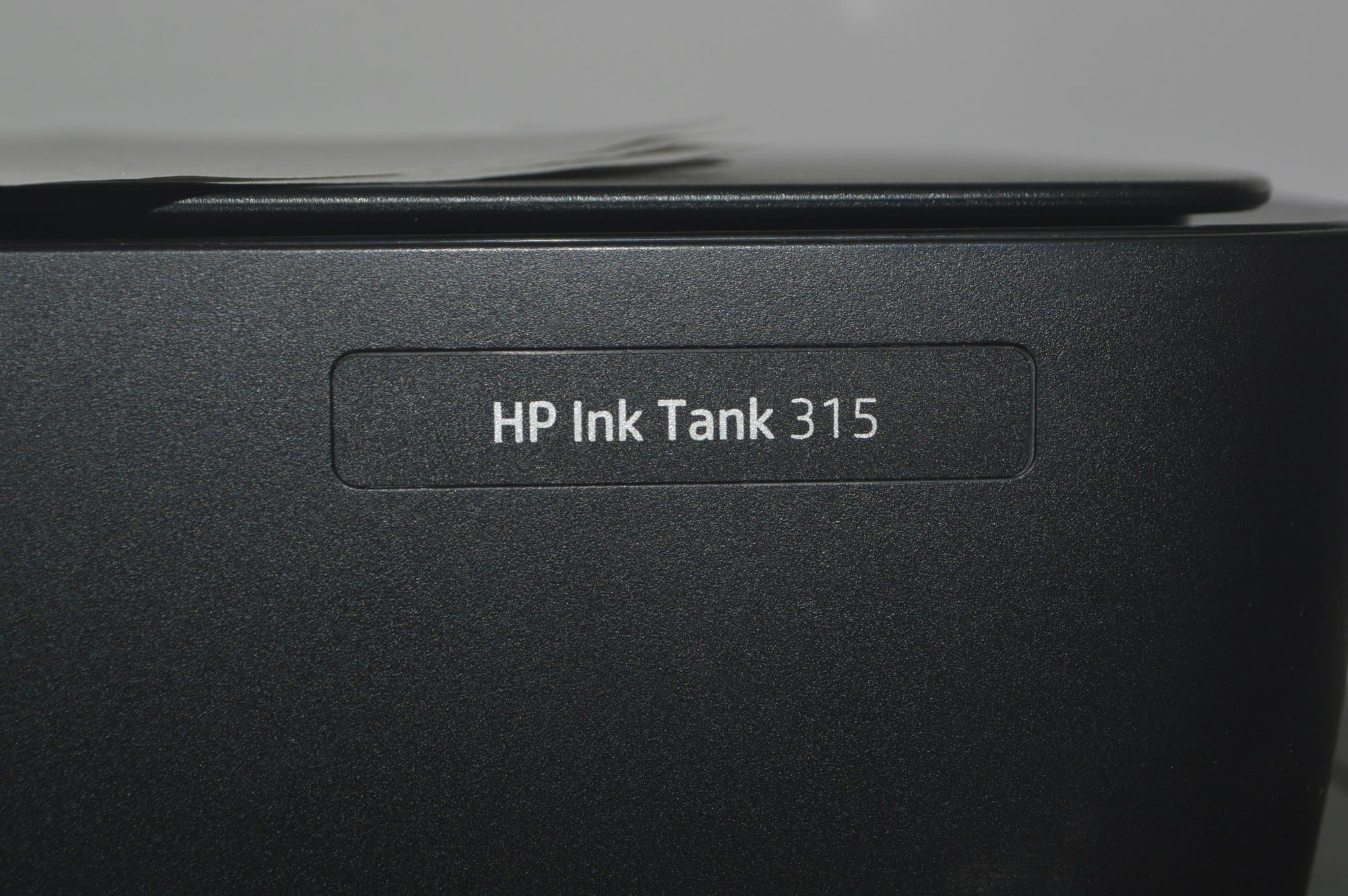 The HP Ink Tank 315 name badge on the front of a black printer