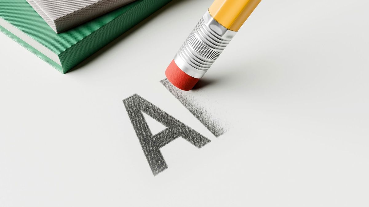 A pencil eraser rubbing out the letters A and I written in pencil, with the I half erased and smearing rather than coming clean, beside a stack of books