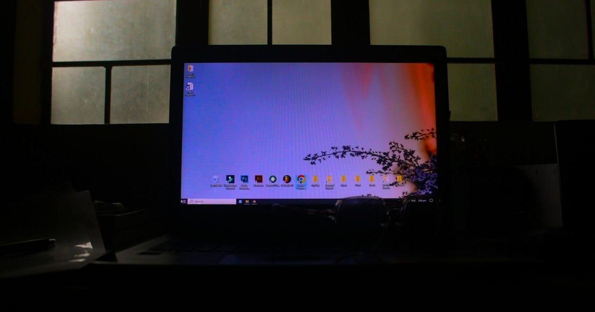A laptop glowing in a dark room. Photo by Ayana Bula on Unsplash.