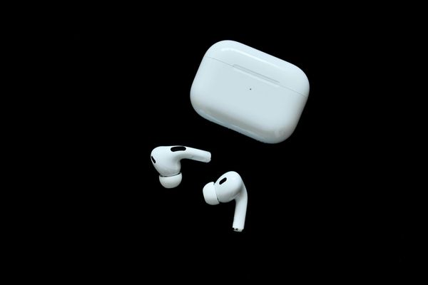 AirPods Pro earbuds and their charging case on a black background.