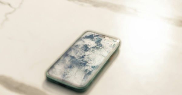 A phone left on a marble cafe table. Photo by Alexandros Giannakakis on Unsplash.