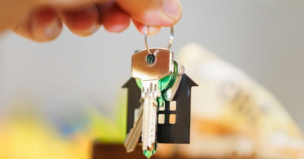 A hand holding a set of keys with a keychain. Photo by Jakub Zerdzicki on Unsplash.