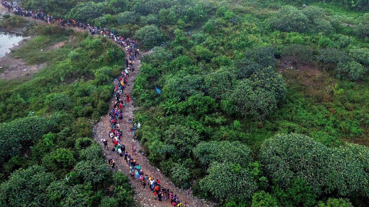 Migrants walk by the jungle near Bajo Chiquito village, the first border control of the Darién Province in Panama. Many global migrants headed to the US land in Ecuador first before making the onward journey through the Darién Gap. Photo: Luis Acosta/AFP/Getty Images