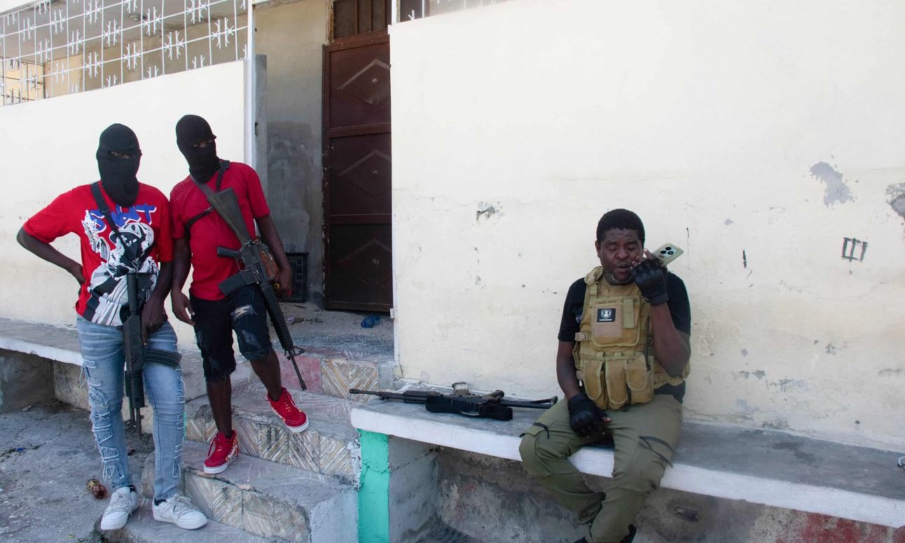 Gang leader Jimmy ‘Barbecue’ Chérizier speaks into his phone before a mission, as two of his men watch, in Port-au-Prince. Photo: Clarens Siffroy/AFP/Getty Images