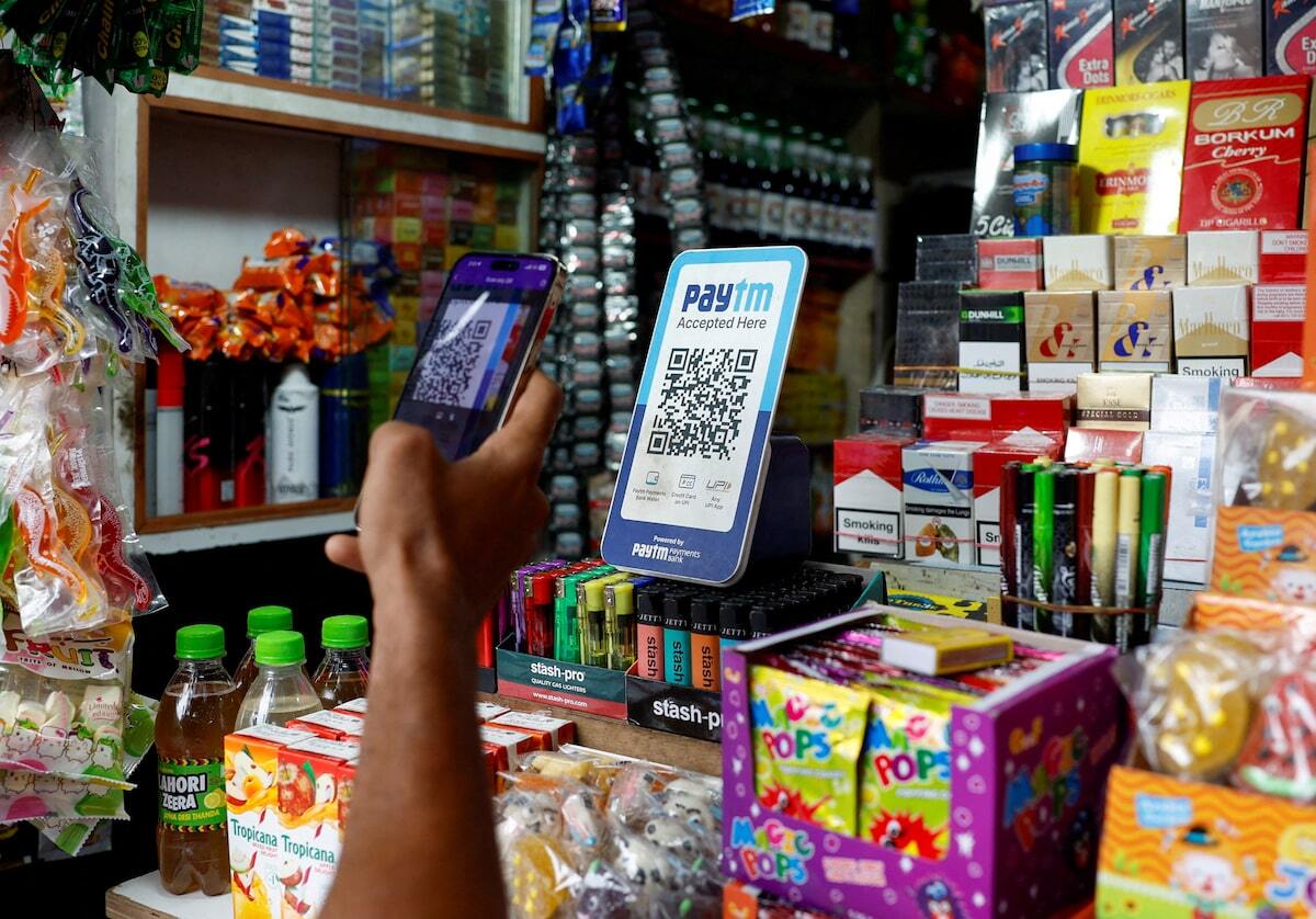 A man uses his phone to scan a QR code of the digital payment app Paytm in Kolkata, India. Photo: Sahiba Chawdhary/Reuters