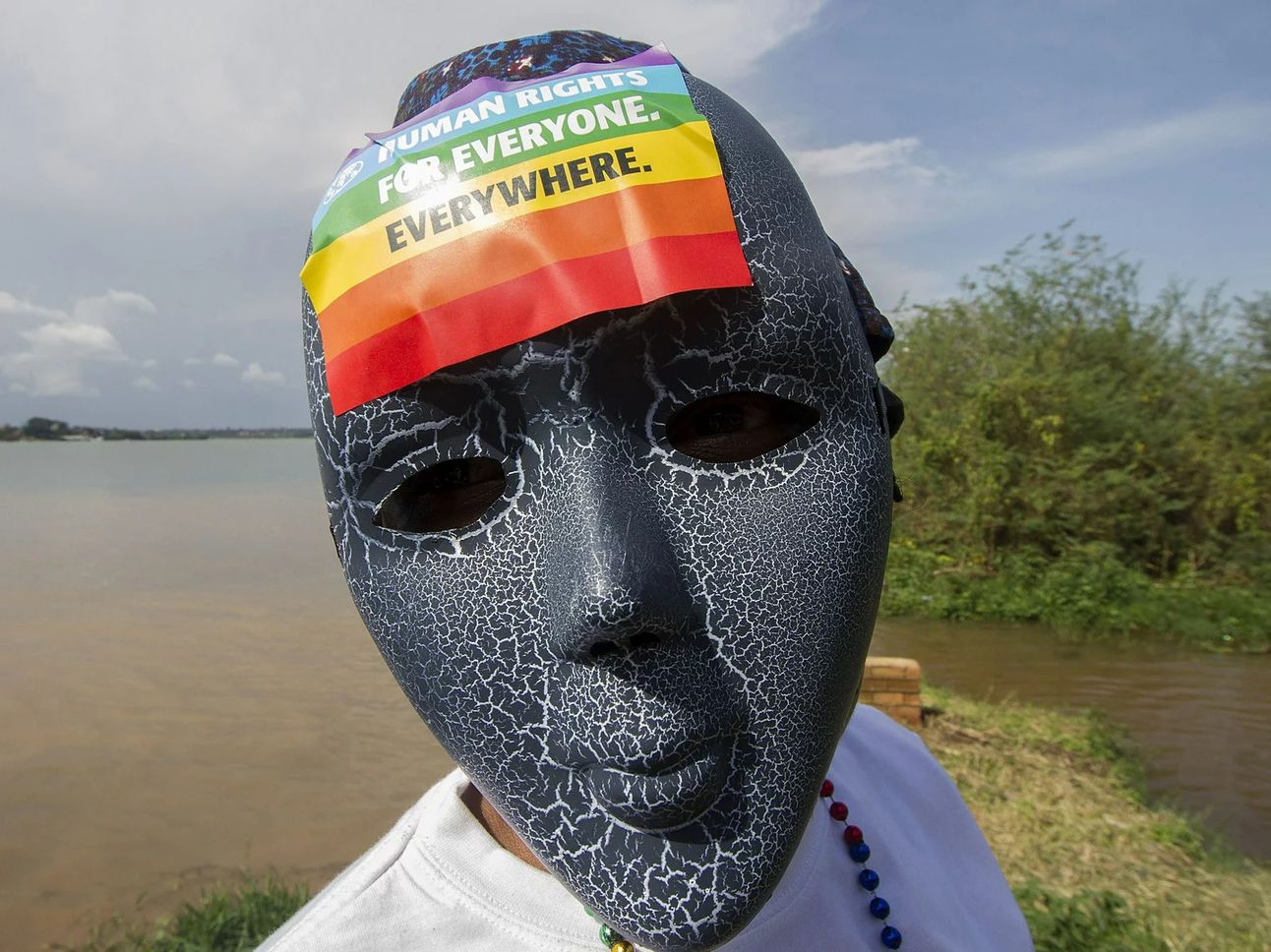 A Ugandan wearing a mask with a rainbow sticker at a Gay Pride parade in 2015. Photo: Isaac Kasamani/AFP via NPR