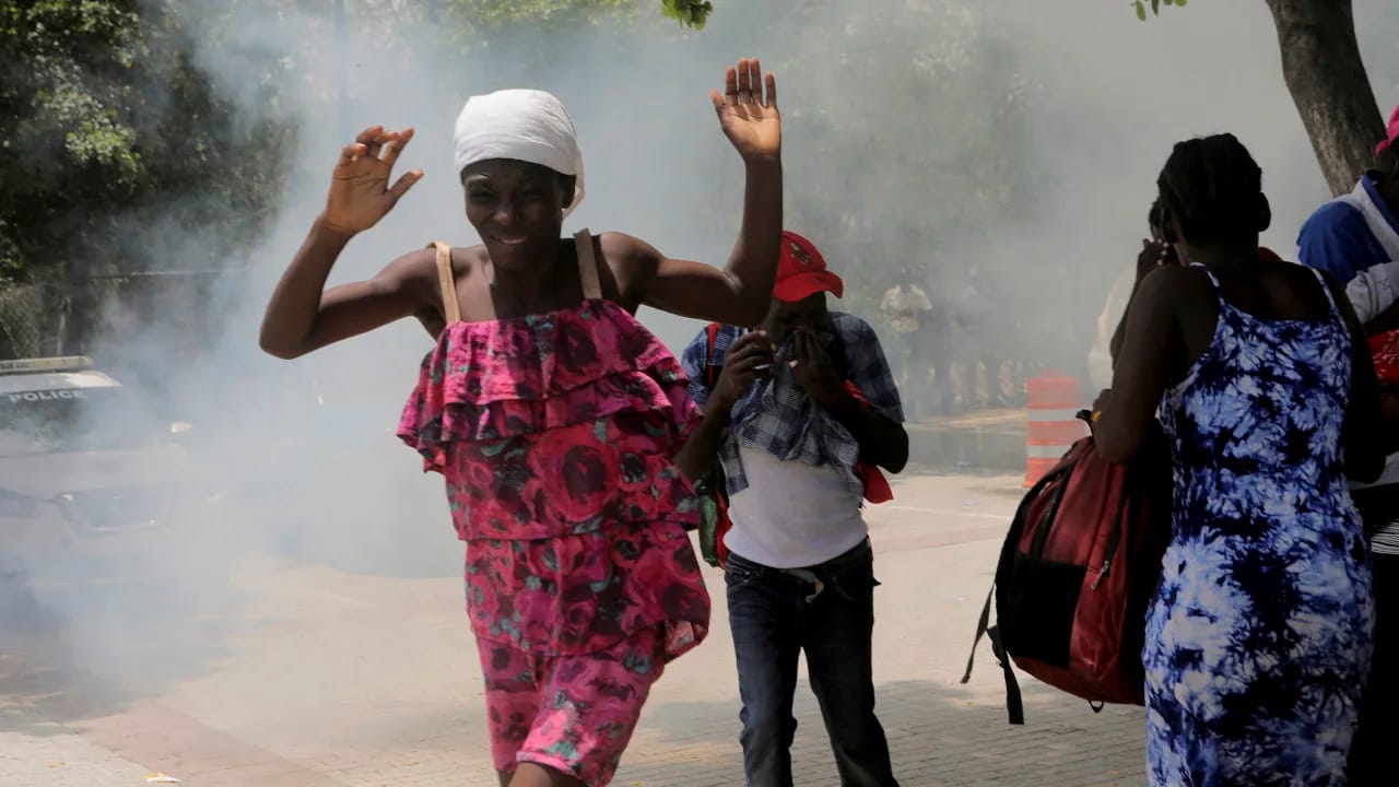 Haitians flee tear gas fired by officers clearing a camp of people at the US embassy seeking to escape the violence of armed gangs on July 25. Photo: Ralph Tedy Erol/Reuters
