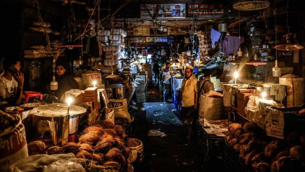 Vendors use candles to light a market in Dhaka during a blackout in early October. Photo: AP