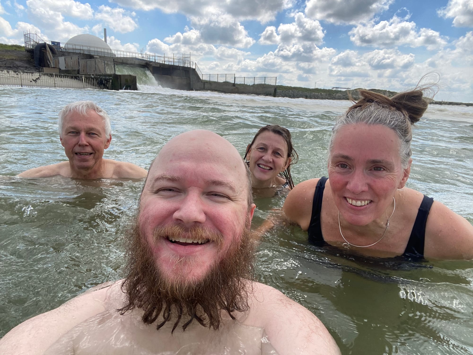Foto van mij en wat anderen van WePlanet die afgelopen jaar hebben gezwommen bij de uitlaat. De centrale is duidelijk zichtbaar op de achtergrond.