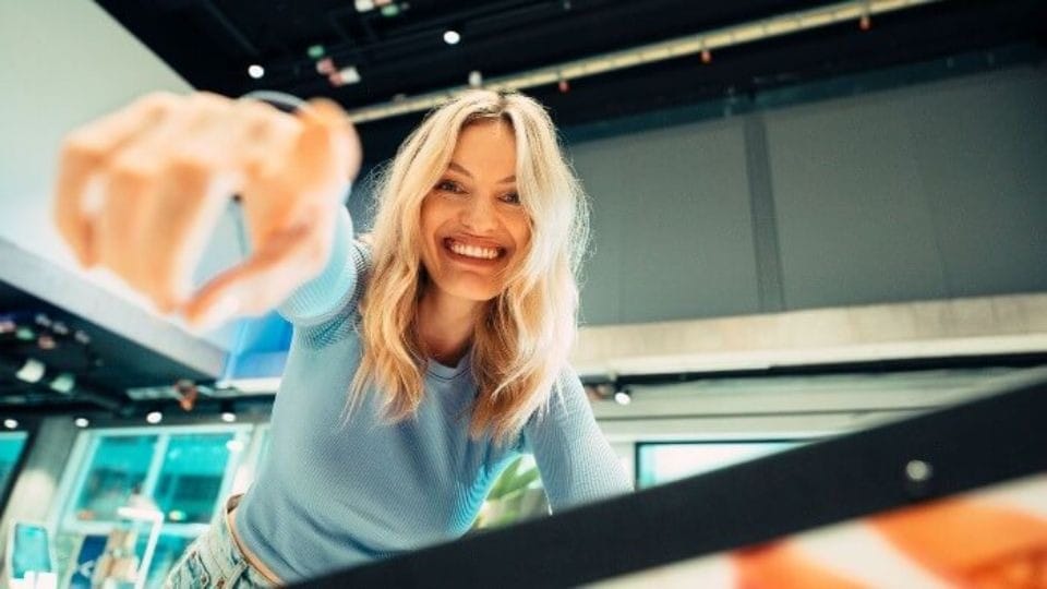 Frau greift im Supermarkt nach einem Einkauf