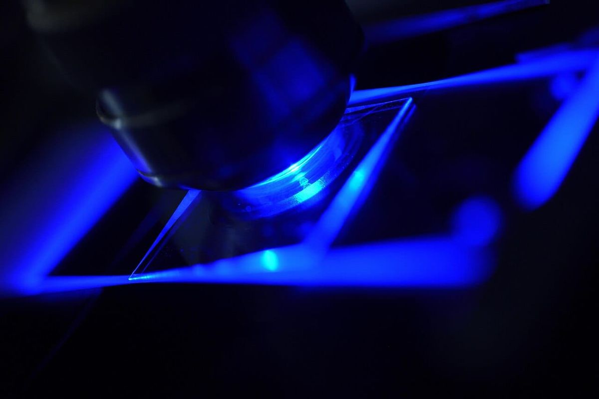 Blau beleuchtetes Fluoreszenzmikroskop als Symbolbild für Laborforschung. Keine Aufnahme aus dem neuen ISAB in St. Gallen.