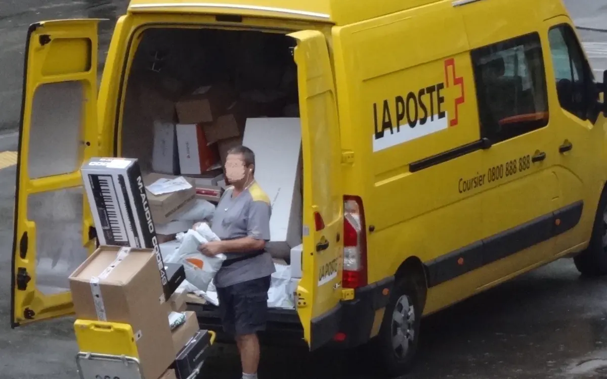 Ein Schweizer Postmitarbeiter transportiert mehrere Pakete zur Zustellung