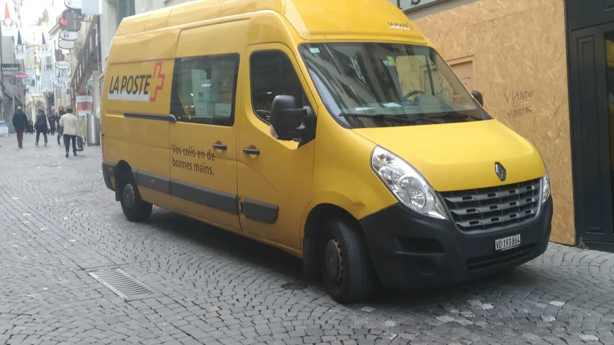 Gelbes Zustellfahrzeug der Schweizerischen Post auf einer Strasse