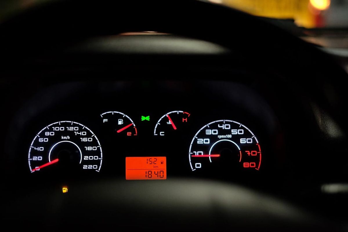 Symbolbild: Auto-Innenraum mit Armaturenbrett und beleuchtetem Tachometer bei Nacht